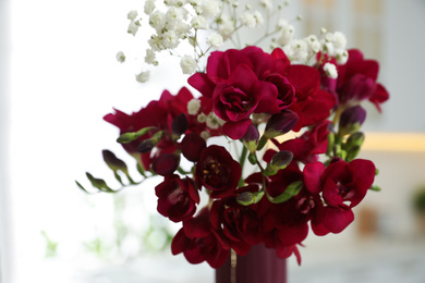 Photo of Beautiful bouquet with freesia flowers in vase indoors, closeup