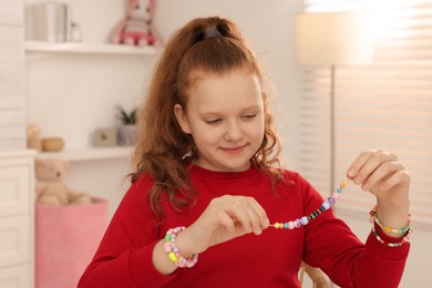 Girl with bright handmade beaded jewelry in room