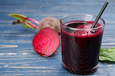 Photo of Freshly made beet juice on blue wooden table