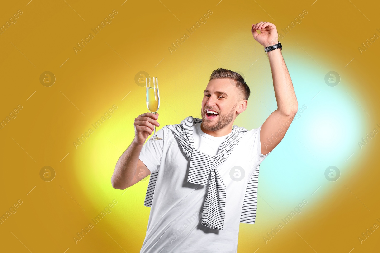 Photo of Portrait of happy man with champagne in glass on color background