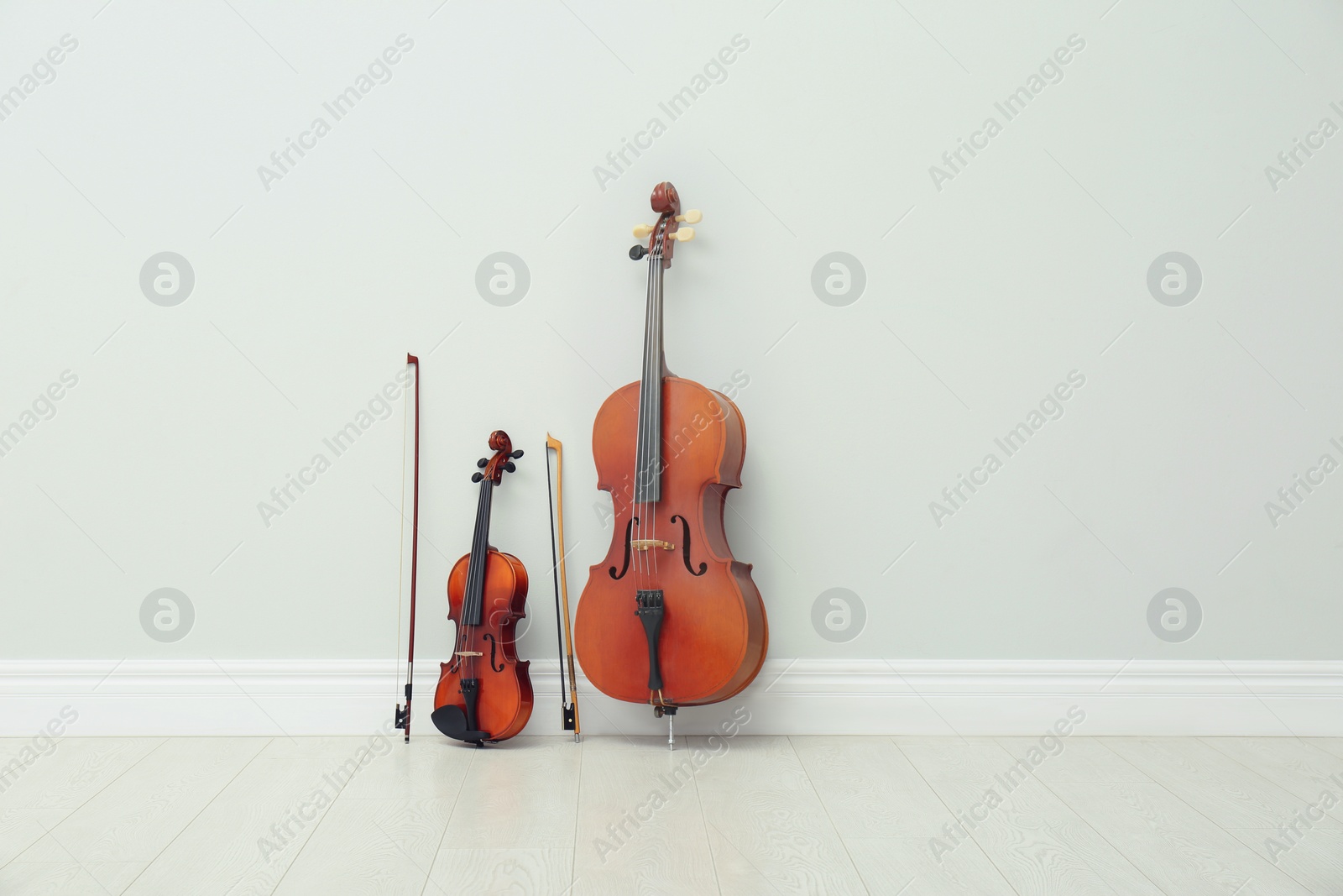 Photo of Stringed musical instruments near white wall indoors