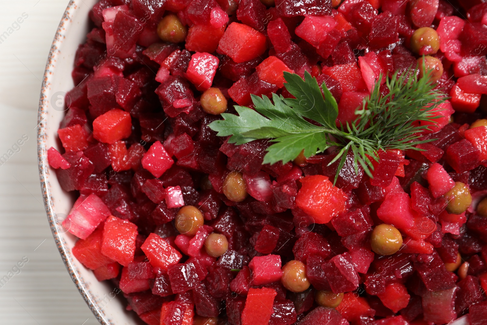 Photo of Bowl of delicious fresh vinaigrette salad on table, closeup