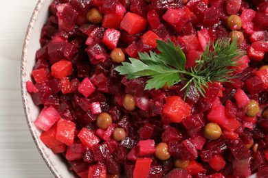 Bowl of delicious fresh vinaigrette salad on table, closeup