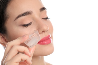 Young woman with ice cube on white background. Skin care