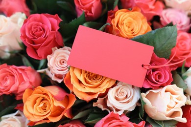 Photo of Bouquet of beautiful roses with blank card, top view