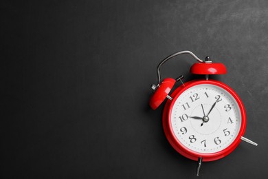 Photo of Alarm clock on blackboard, top view with space for text. School time