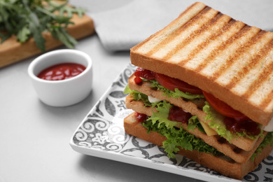 Photo of Yummy sandwich with tomato sauce served on grey table