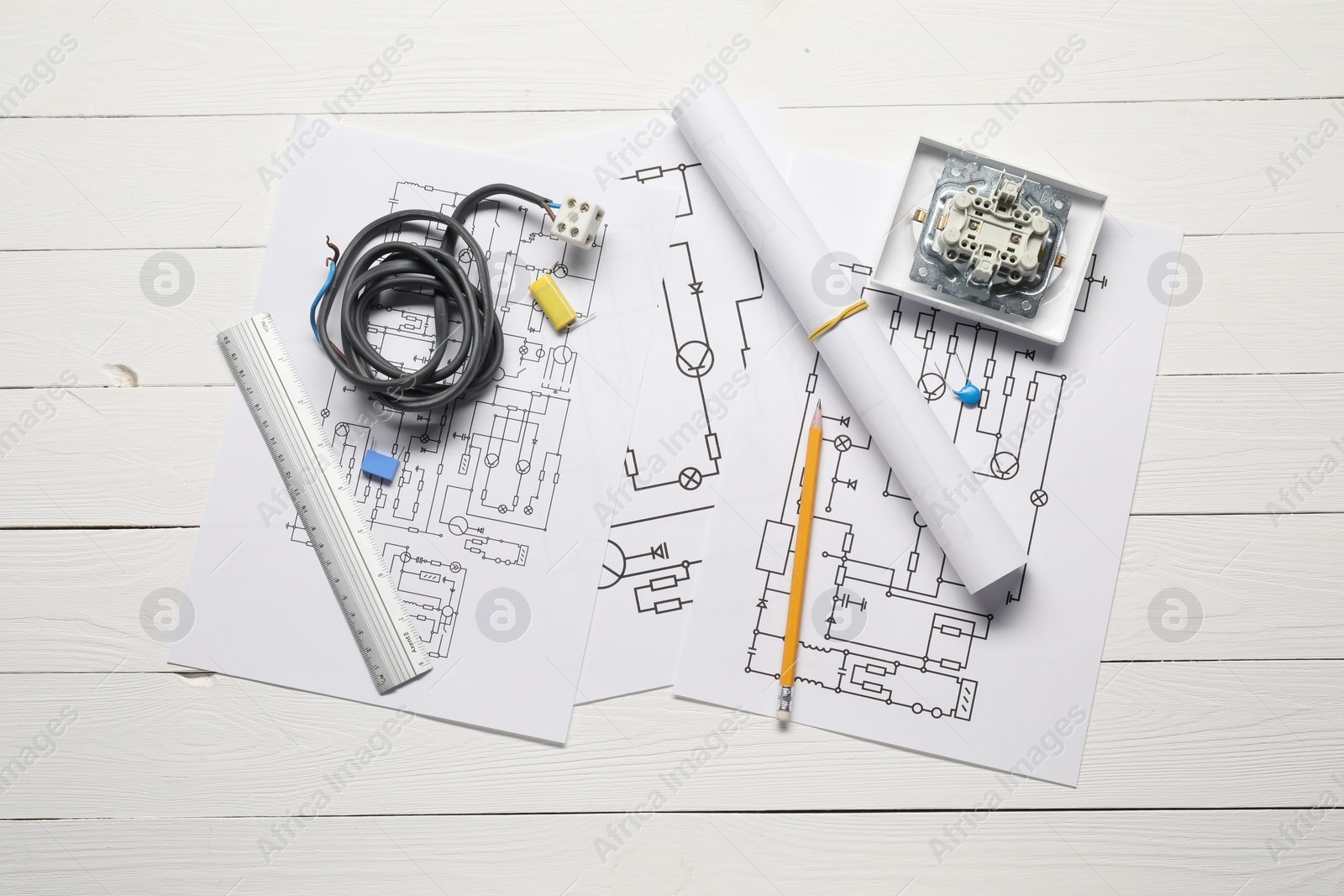 Photo of Wiring diagrams, wires and office stationery on white wooden table, flat lay