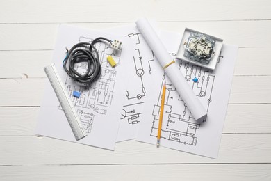 Wiring diagrams, wires and office stationery on white wooden table, flat lay