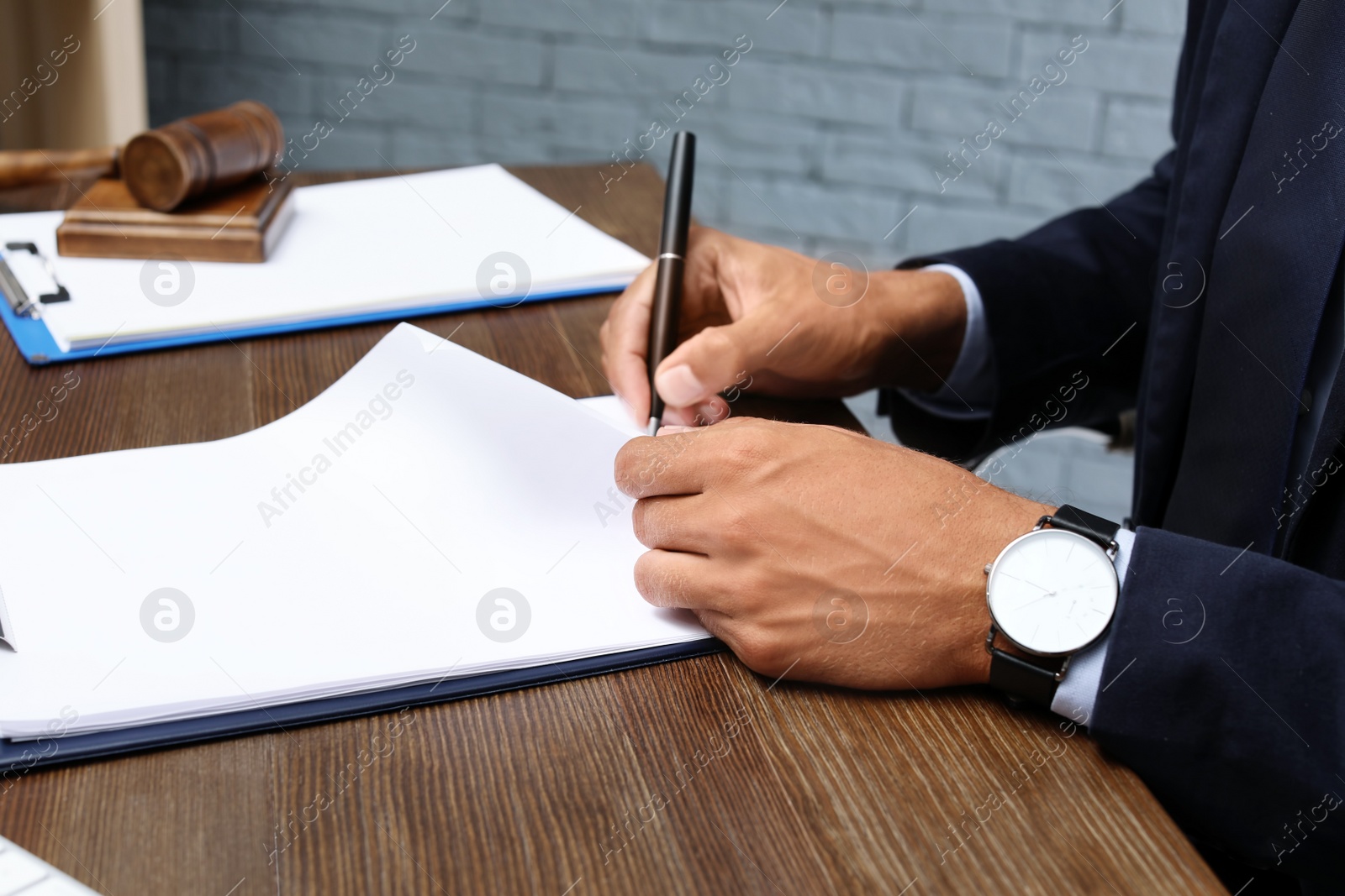 Photo of Male lawyer working with documents at table in office, closeup