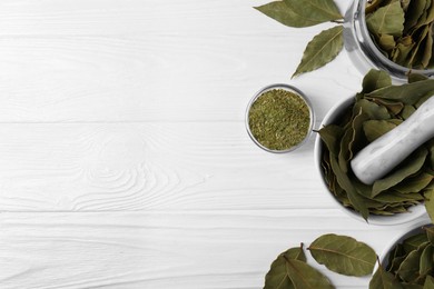 Photo of Whole and ground bay leaves on white wooden table, flat lay. Space for text