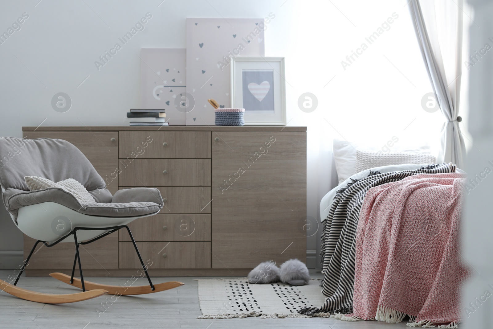 Photo of Modern chest of drawers in beautiful bedroom. Interior design