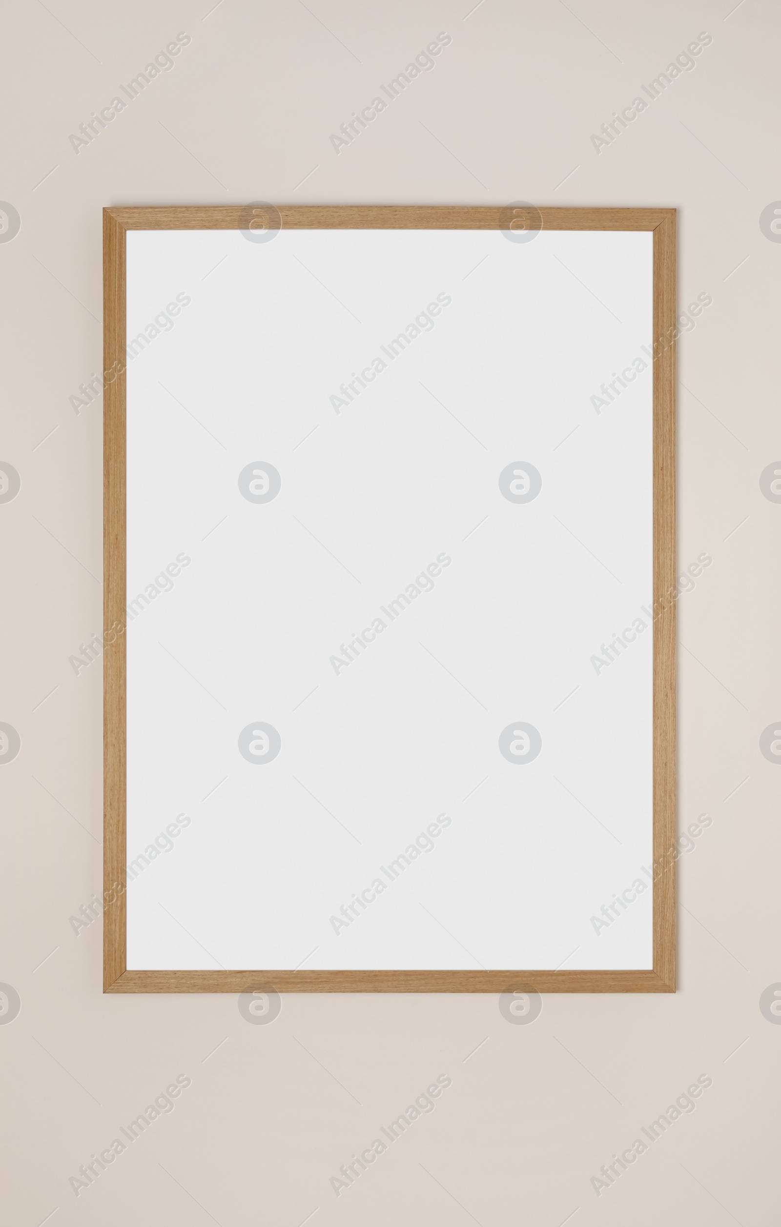 Photo of Blank frame hanging on light wall. Space for design