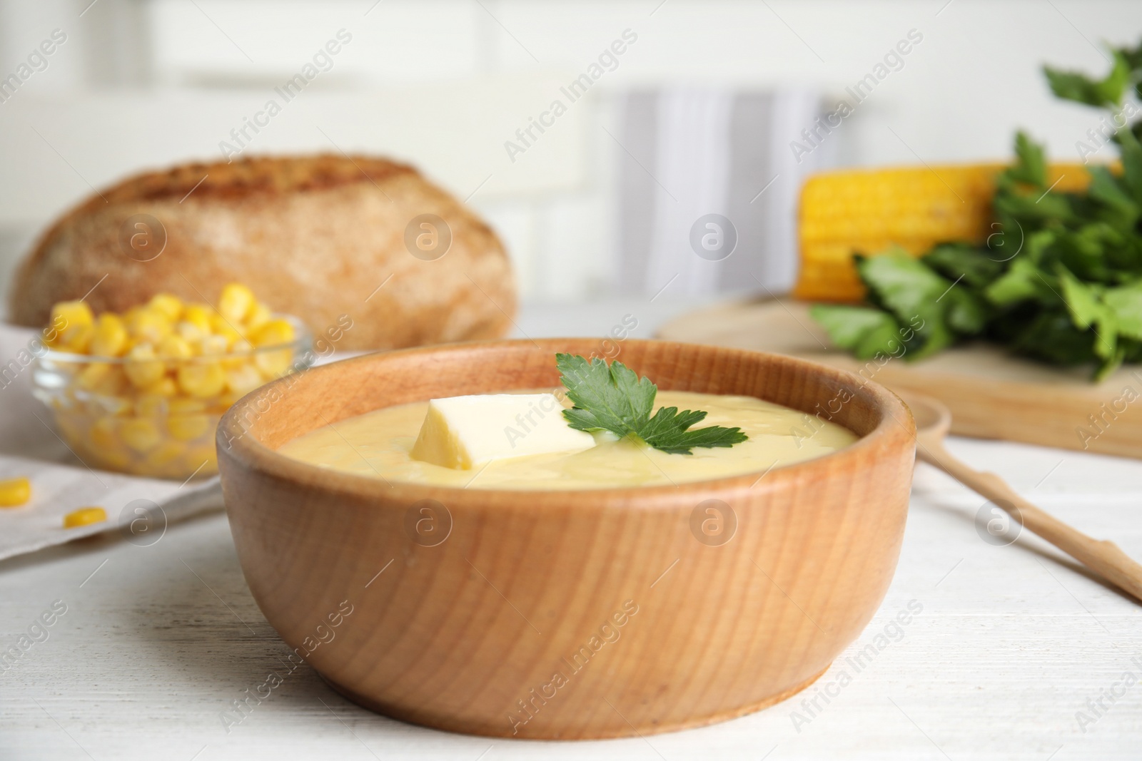 Photo of Delicious corn cream soup served on white wooden table