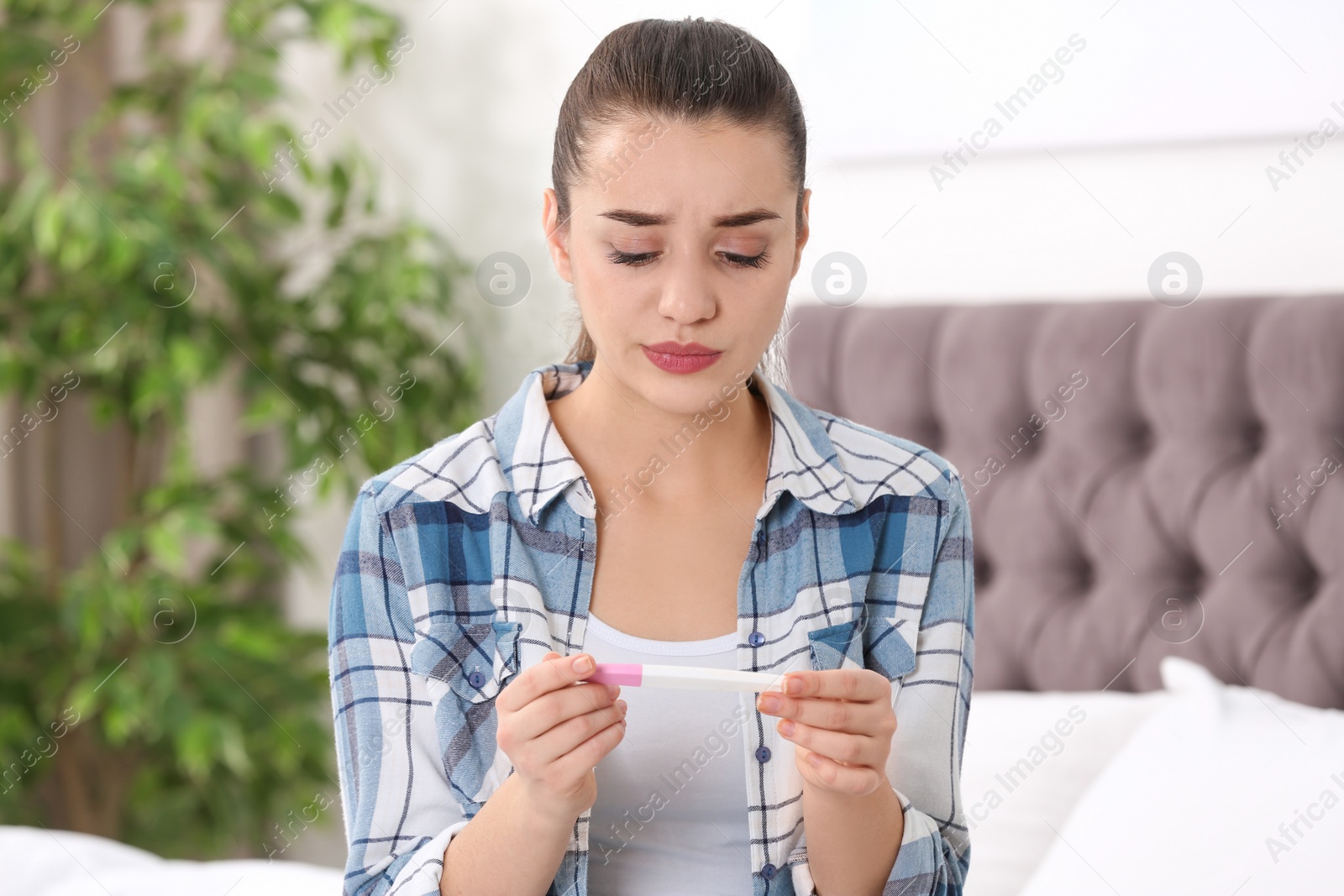 Photo of Young woman with pregnancy test at home. Gynecology and childbirth