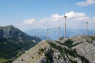 Image of Alternative energy source. Wind turbines and mountains outdoors 