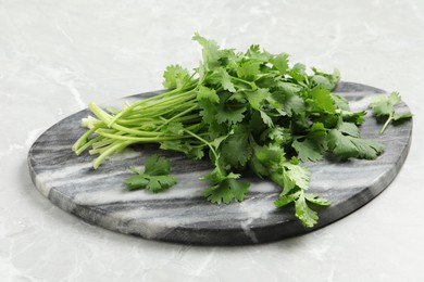 Photo of Bunch of fresh aromatic cilantro on light marble table