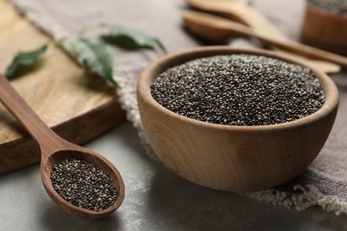 Photo of Chia seeds in bowl and spoon on table