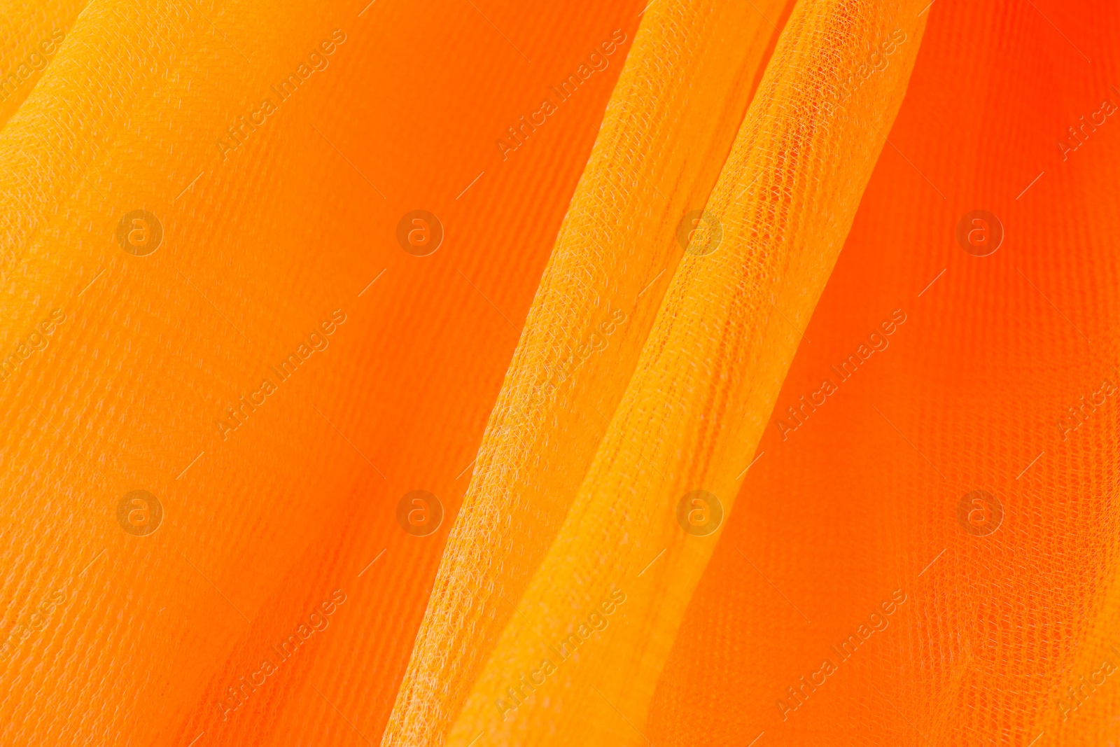 Photo of Texture of orange tulle as background, closeup