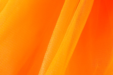 Photo of Texture of orange tulle as background, closeup