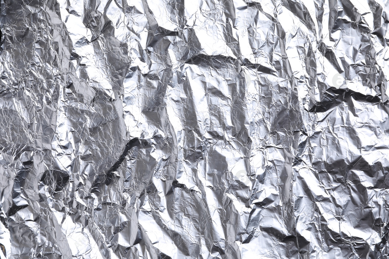 Photo of Crumpled silver foil as background, closeup view