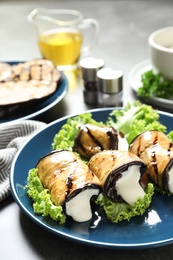 Photo of Plate with fried eggplant rolls on table, closeup