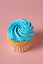 Delicious cupcake with bright cream on pink background