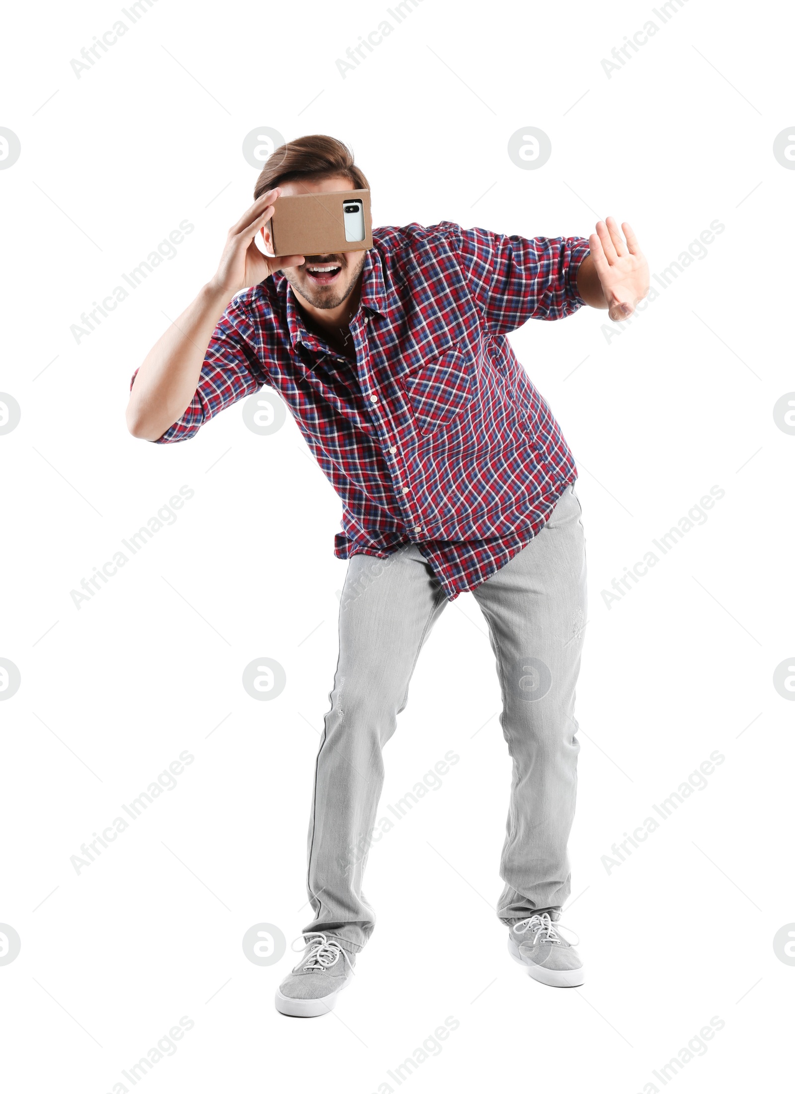 Photo of Young man using cardboard virtual reality headset, isolated on white