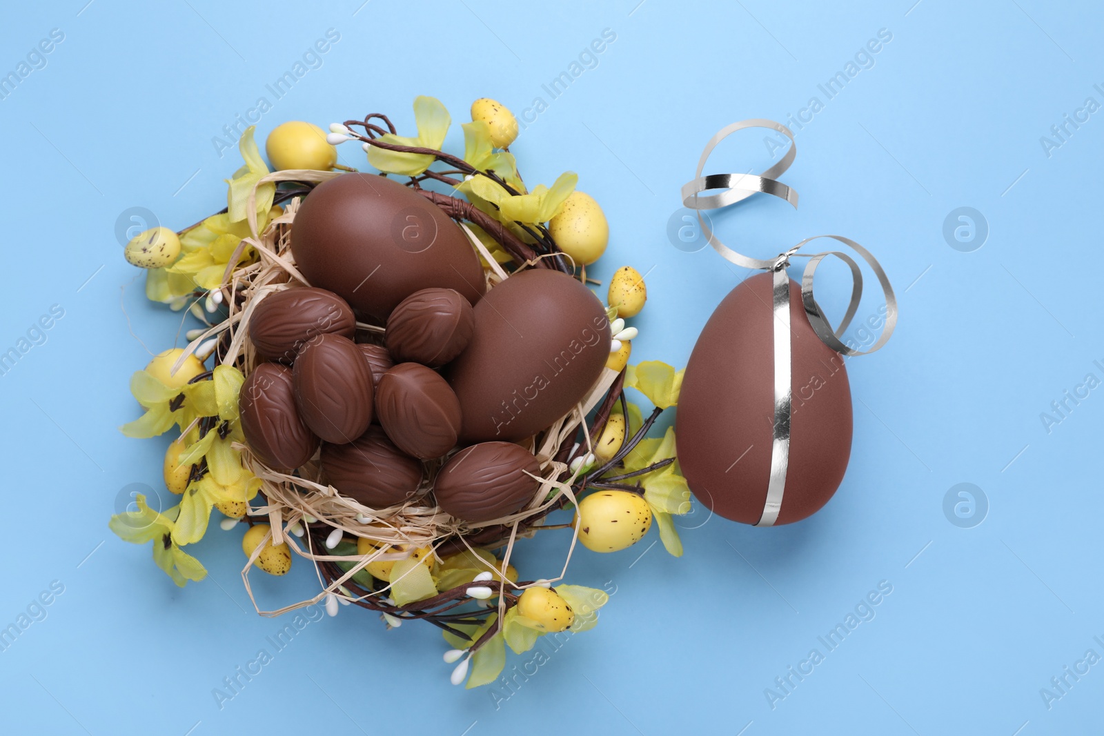 Photo of Delicious chocolate eggs on light blue background, flat lay