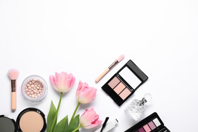 Flat lay composition with different makeup products and beautiful spring flowers on white background, space for text