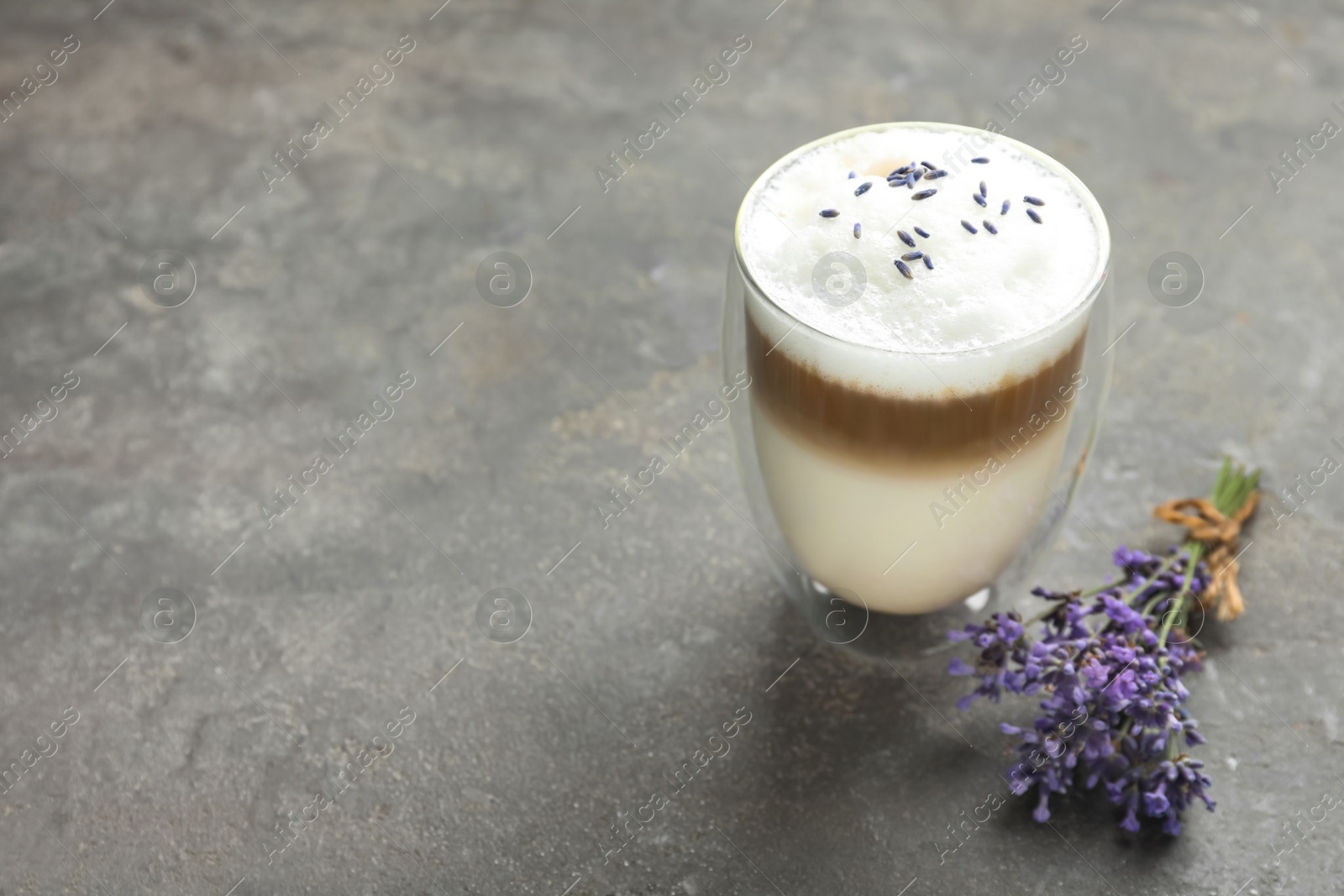 Photo of Delicious latte with lavender on grey table. Space for text