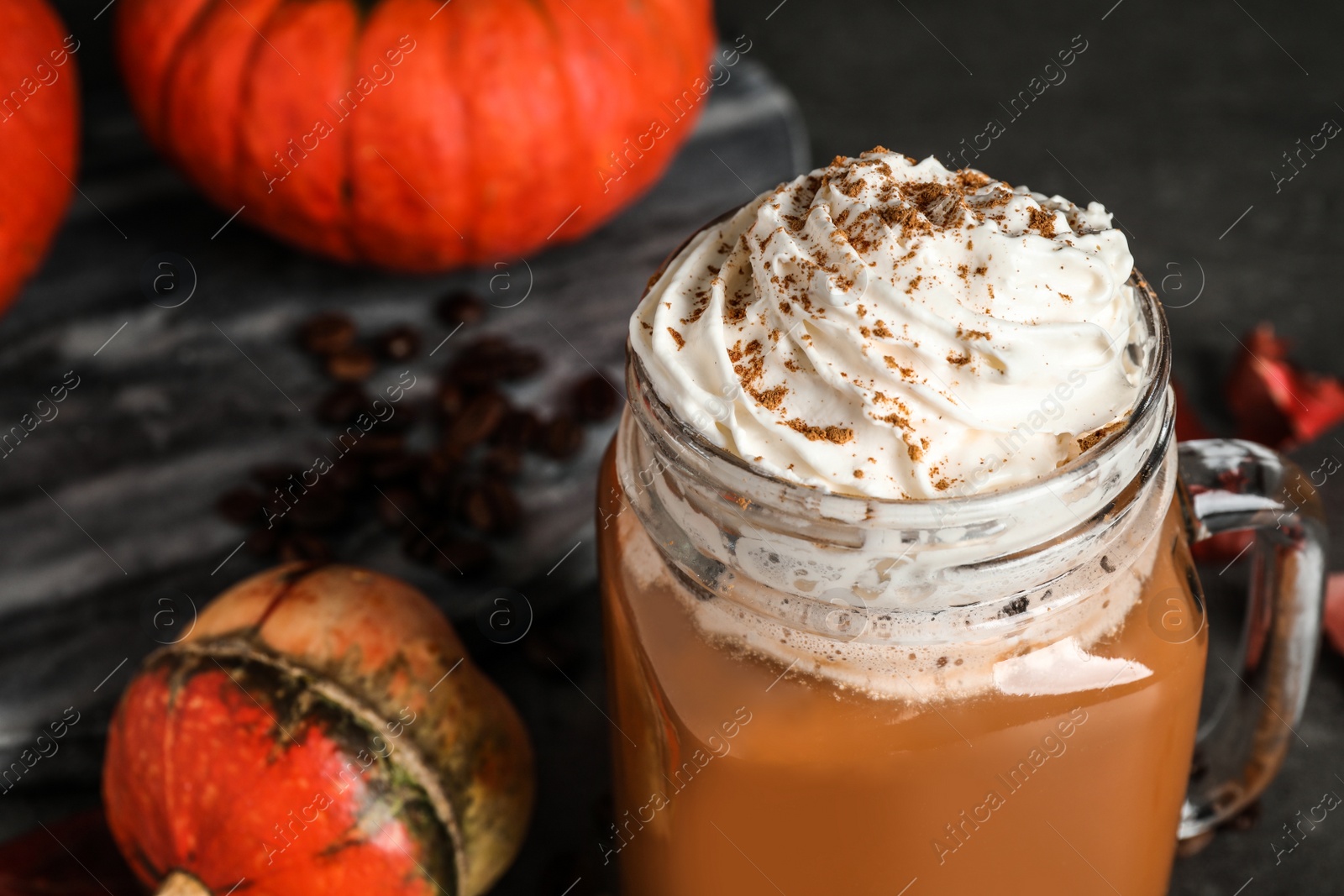 Photo of Mason jar with tasty pumpkin spice latte on grey table, closeup