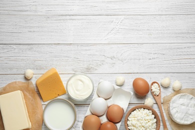 Different dairy products on white wooden table, flat lay. Space for text