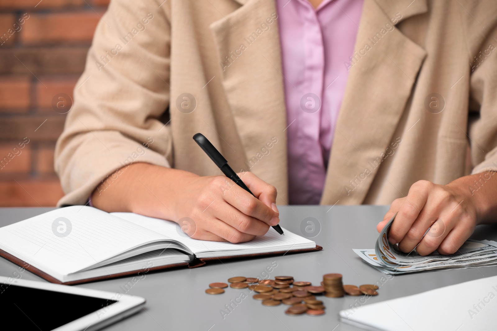 Photo of Woman counting American money at table indoors, closeup