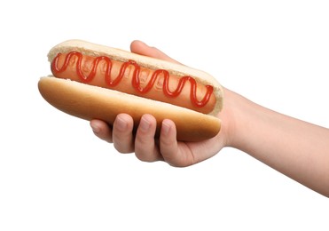 Woman holding delicious hot dog with ketchup on white background, closeup