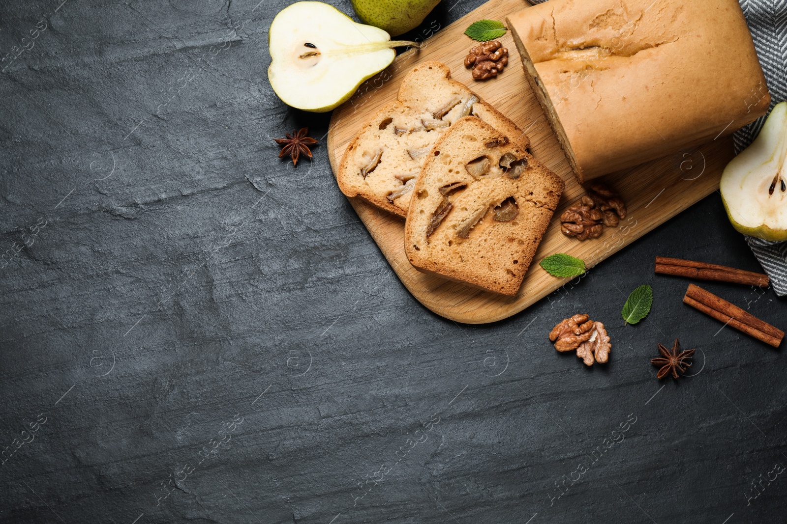 Photo of Flat lay composition with pear bread on black slate table, space for text. Homemade cake