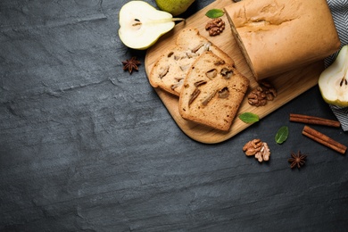 Photo of Flat lay composition with pear bread on black slate table, space for text. Homemade cake