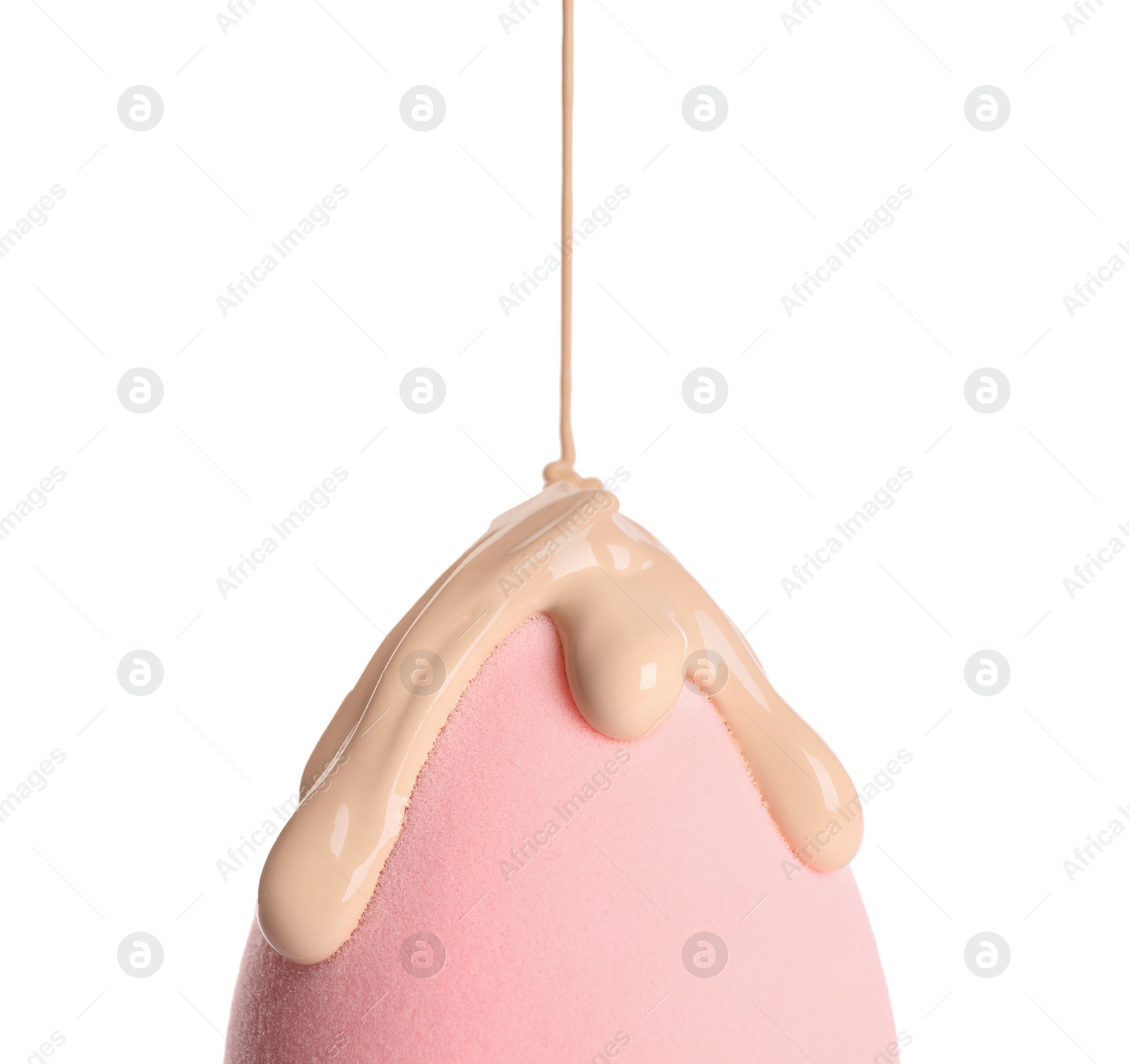 Photo of Pouring skin foundation onto makeup sponge on white background