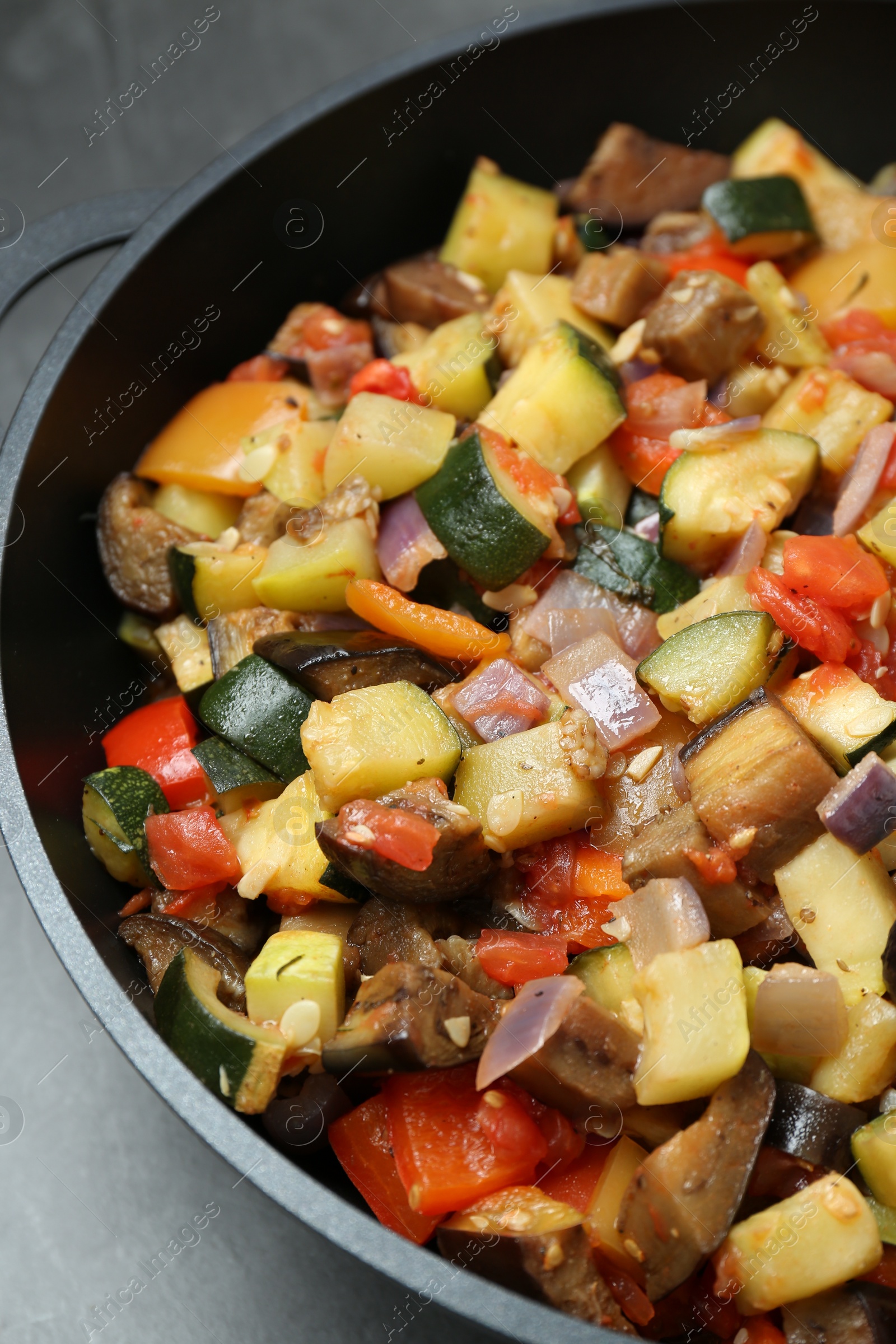 Photo of Delicious ratatouille in baking dish on grey table, closeup