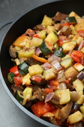 Photo of Delicious ratatouille in baking dish on grey table, closeup