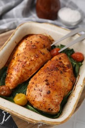 Photo of Baked chicken fillets with vegetables and marinade on white table, closeup