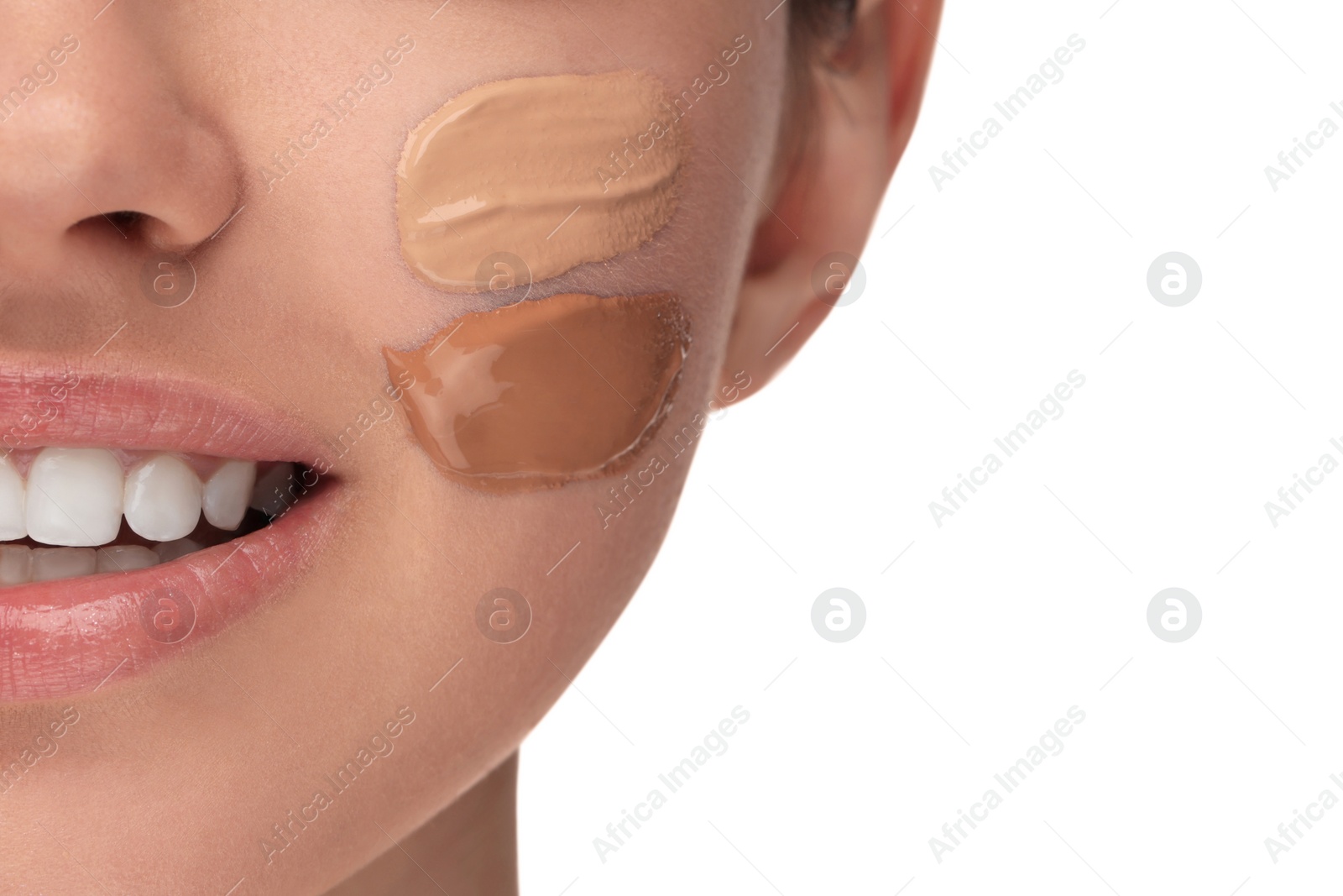 Photo of Teenage girl with swatches of foundation on face against white background, closeup