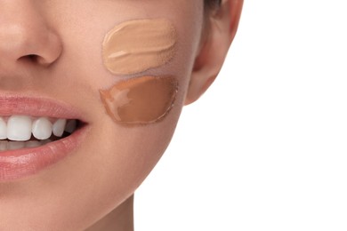 Teenage girl with swatches of foundation on face against white background, closeup