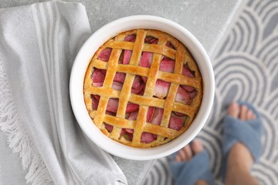 Baking dish with tasty apple pie on light grey table, top view