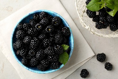 Tasty ripe blackberries and leaves on light table, flat lay