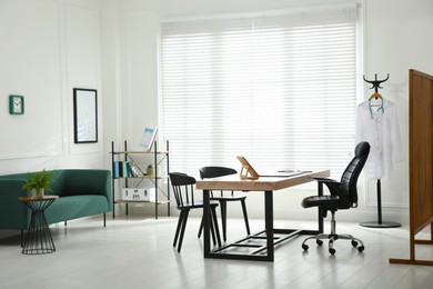 Modern medical office interior with doctor's workplace and sofa