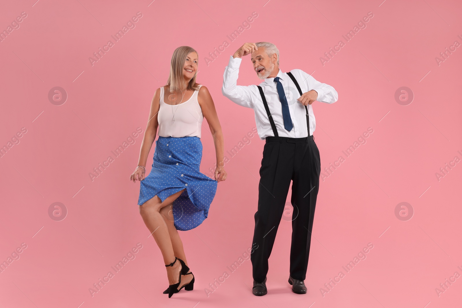 Photo of Senior couple dancing together on pink background