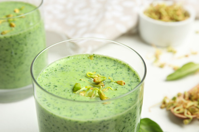 Photo of Green buckwheat smoothie on white table, closeup