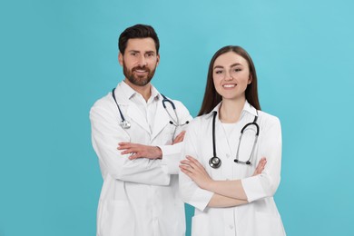 Photo of Nurses in medical uniforms with stethoscopes on light blue background