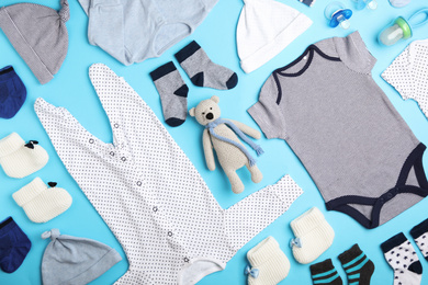 Photo of Flat lay composition with child's clothes and toy bear on light blue background